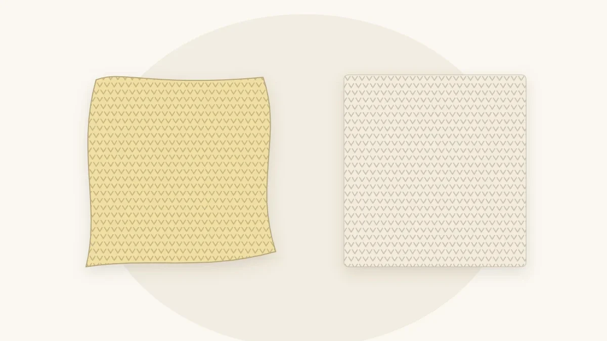 A small crocheted blanket in butter yellow with uneven wavy side edges beside a neat straight-edged cream blanket