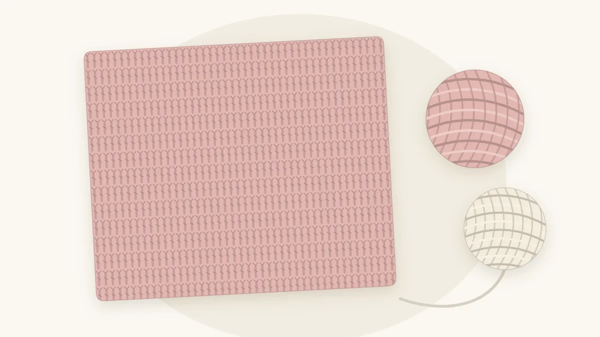 A dusty rose double crochet baby blanket lying flat with visible tall stitch rows, beside two yarn balls
