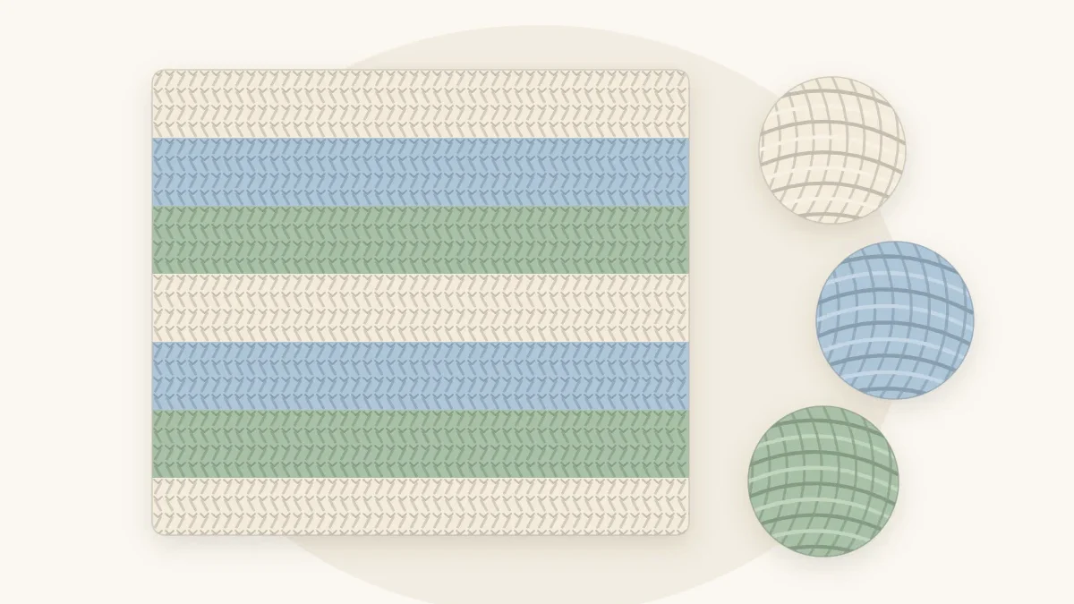 A striped crochet baby blanket with wide horizontal stripes in cream, pale blue and sage, lying flat with three matching yarn balls